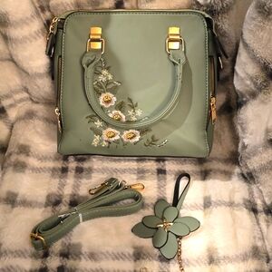 The handbag in Pale Green has embroidered  flowers on 1 side of the front